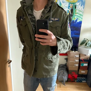 Ralph Lauren militär jacka  - Säljer en grön militärinspirerad jacka från Ralph Lauren  med flera patchar och dragkedja framtill.