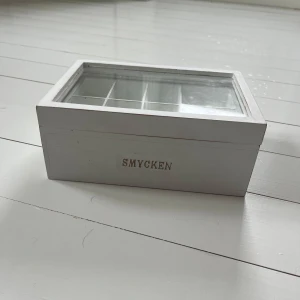 Smyckes förvaring - Fin och praktisk smyckes förvaring💕lådan har två ”våningar” och locket är av glas. Resten av lådan är i trä. Första våningen är uppdelat små fack medan den andra är ett enda stort fack. Det har rum för många smycken. jag vet tyvärr inte vart det är köpt då jag fått det i present. Det har inga större defekter, enbart små streck som antagligen går att sudda bort. 
