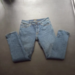 Blå jeans från Jack & Jones, W29 L30 -  blå jeans från Jack & Jones med raka ben och snygga kontrastsömmar. Modellen har fem fickor. Slim Glenn. Aldrig använda