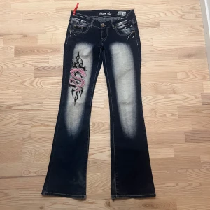 Crazy Age bootcut jeans - Mörkblå bootcut jeans från Crazy Age i storlek 38. Snygga rosa detaljer och blekta partier. Sitter som S