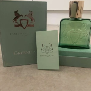 Parfums de Marly Greenley 125ml - Greenley från Parfums de Marly är en lyxig parfym i en stilren grön glasflaska med guldigt lock. Flaskan har en elegant relief med två hästar och en sköld med årtalet 1743. Kommer i originalkartong och med tillhörande booklet. Volym: 125ml. Använt cirka 5ml av flaskan annars helt perfekt