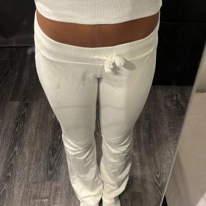 Nelly Vita mjukisbyxor - Säljer ett par vita mjukisbyxor från nelly med bred resår i midjan och snörning framtill. Byxorna har en rak passform med lite utsvängda ben och är tillverkade i mjukt bomullsmaterial. Perfekta för en chill och avslappnad look.