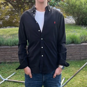 Svart Ralph lauren skjorta  - Säljer denna stilrena och snygga svarta Ralph Lauren skjorta. Skjortan är i bra skick. Modellen är M slim fit. Har du några frågor? Tveka inte att höra av dig. Allt gott från Deluxe garderoben⭐️