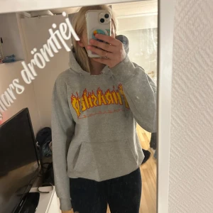 Grå Thrasher hoodie strl S - Säljer en grå Thrasher hoodie i strl s, jätte bekväm och skön men är lite traskig vid halsen dock men inget man tänker på så mycket, väldigt fin i skicket förutom vid halsen där jag råkat haft sönder men annars väldigt fin!!