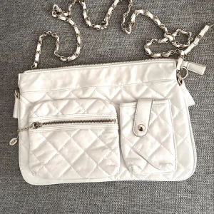 Vit väska  - Väska med gulddetaljer i fuskskinn . Storlek 26*18 cm. Använd vid ett tillfälle så i fint skick. 