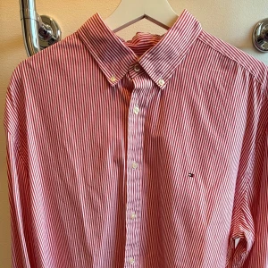 Rödvit randig skjorta Tommy Hilfiger XL - Snygg röd och vit randig skjorta från Tommy Hilfiger i storlek XL. Skjortan har klassisk krage med knappar, lång ärm och diskret logga broderad på bröstet. Tillverkad i mjuk bomull och perfekt för en clean och stilren look.