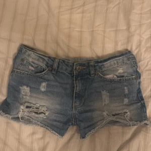Lågmidjade slitna jeansshorts  - Snygga lågmidjade jeansshorts liknande de från Hollister med slitna detaljer. Passar även storlek 36 skulle jag säga. Pris kan diskuteras😊