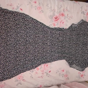 Blommig långklänning Holly & White - Supersöt långklänning från Holly & White by Lindex i marinblått med små vita blommor. Klänningen har en smickrande passform och är perfekt för dig som gillar romantiska mönster. Tillverkad i ett lätt och skönt material.