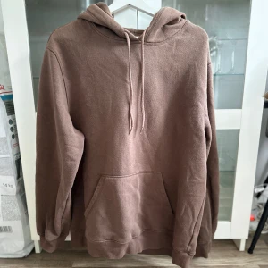 Brun hoodie - En brun hoodie i relaxed/oversized passform i storlek L från H&M köpt secondhand (i samma skick), har använts 2 gånger. Finns en fläck vid fickan som inte gick bort i tvätten, den är även lite nopprig men det går att ta bort med nopperborttagare. FÖRST TILL KVARN!