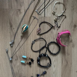 Mix av smycken: halsband, armband och örhängen - Flera smycken säljes tillsammans: halsband i silver- och guldfärg, armband i svart, rosa och vitt, samt örhängen med turkosa stenar. Det finns detaljer som stjärnor, berlocker, pärlor och flätade band. Perfekt för dig som gillar att variera din stil.