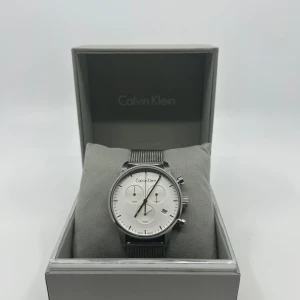 Calvin Klein klocka / herrur /5 ATM / rostfritt stål / 43mm - Calvin Klein klocka / herrur /5 ATM / rostfritt stål / 43mm  Skick: nytt batteri och fint skick.  Fås med en klockbox (inte alltid nödvändigtvis den som är på bild om det inte är original som tillhör klockan).   Övrigt skick enligt bilder.  Tveka inte att fråga om du undrar något.  Villkor mm finns i profilen Mvh Refinedwatches