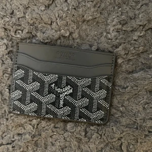 Korthållare - Säljer ett stilrent kortfodral med rutigt mönster. Fodralet har flera fack för kort och är perfekt för dig som vill ha något smidigt och snyggt att bära med dig. Passar perfekt i fickan