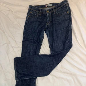 Levi's 572 Bootcut jeans i mörkblå denim - Klassiska Levi's 572 Bootcut jeans i mörkblå tvätt. Lite slitna fickor men inget som direkt syns, hittar inte storleken men skulle säga xs/s!