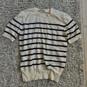 Randig kortärmad tröja i bomull - Säljer en beige tröja med korta ärmar och rund halsringning.🤍