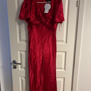 Balklänning - Snygg röd långklänning från Little Mistress med korta ärmar och v-ringad hals. Nyskick med prislappen på. 