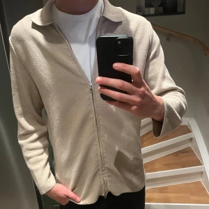 Beige zip-up - Schysst, simpel beige zip-up från H&M som är sällsynt. Knappt använd och i mycket bra skick. Nypris: Ca 500kr. Mitt pris: 200kr
