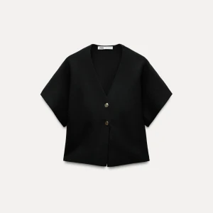 Svart v-ringad tröja från Zara - Stilren svart tröja från Zara med v-ringning och korta ärmar. Västen har två knappar framtill och som ger en modern look.