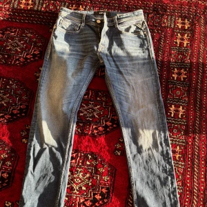 Replay blå jeans straight fit - Säljer ett par klassiska blå jeans från Replay med raka ben och normal passform. Jeansen har fem fickor, dragkedja och knapp i gylfen samt tydliga Replay-detaljer på bakfickan. Helt nya