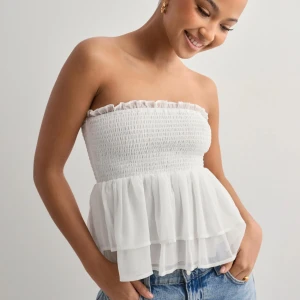 Vit topp - Jättesöt topp från Nelly💕inte min stil så har aldrig kommit till användning, därför fint skick! Orginalpriset är 299.