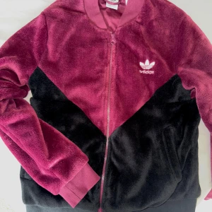 Vinröd bomberjacka från Adidas - Väldigt fin och knappt använd bomberjacka ifrån adidas! Tyget är super mysigt! Storlek 36