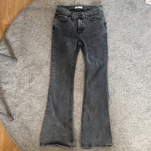 Grå bootcut jeans från Gina Tricot - Säljer ett par grå bootcut jeans från Gina Tricot, modell Perfect Jeans. De är petit alltså för folk som är kortare. Jeansen har klassisk femficksdesign, normal passform upptill och utsvängda ben. Perfekta för dig som gillar en retroinspirerad look.