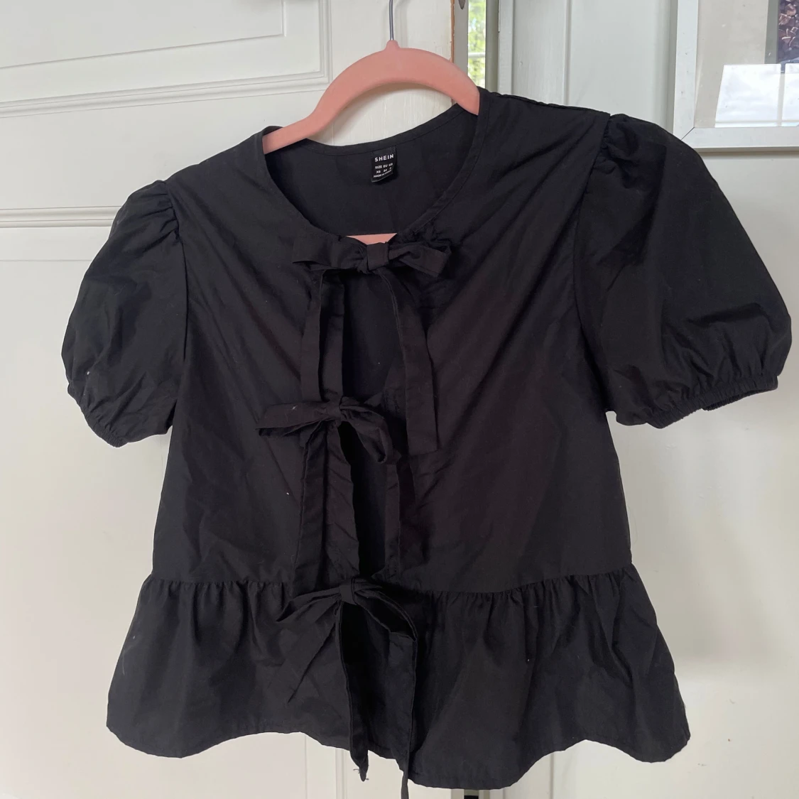 Svart blus med rosetter