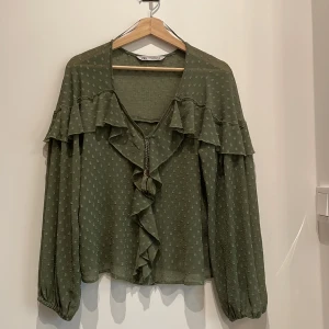 Grön tunn blus från Zara - Görn tunn blus med toffsar i fram, från Zara. Använd en handfull gånger, dvs är i nyskick. 