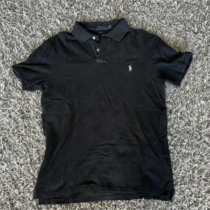 Polo Ralph Lauren piké - Klassisk svart pikétröja från Polo Ralph Lauren med broderad logga på bröstet. Storlek L i slimfit 