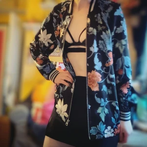 Blommig variety jacka med dragkedja - Säljer en jätte färg glad jacka med blommigt mönster. Jackan har en dragkedja framtill och ribbade muddar vid ärmslut. Perfekt för vår och sommar när du vill sticka ut lite extra!