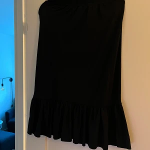 Svart volangkjol från xoxo friends - Säljer en svart kjol från xoxo friends i storlek 158/164. Kjolen har en enkel design med volang nertill som ger en snygg touch. Perfekt för dig som gillar stilrena plagg med lite extra detalj.