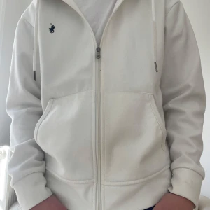 Vit hoodie Ralph Lauren - Säljer en  vit hoodie från Ralph Lauren. Extremt snygg nu till sommaren och passar med allt. Knappt använd som ni ser. Har fint märke och du får bra pris. Nypris är 1500+