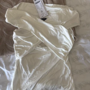 Vit omlotttopp från Gina - Jättefin vit omlotttopp från Gina som inte går att köpa längre. Helt oanvänd med prislapp kvar! 