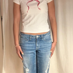  T-shirt från Nelly. - Säljer en vit T-shirt från Nelly i bra skick(ändas använd fåtal gånger). Med ett motiv i form av en röd roset på framsidan. Superbra sommar tröja att ha till en kjol eller shorts. Pris kan diskuteras. 💕