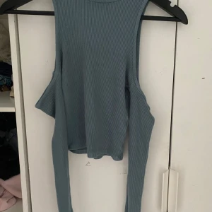Blå ribbad långärmad topp från Pull&Bear - Trendig blå ribbad långärmad topp från Pull&Bear med öppen axel och cool cut-out-detalj. Perfekt för dig som vill sticka ut med en unik och modern stil. Mjuk och stretchig i materialet pris kan diskuteras.