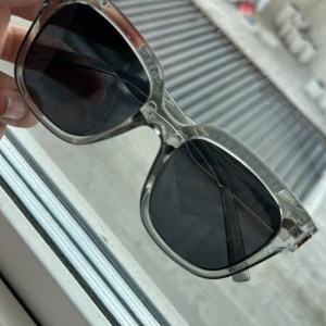 Transparenta fyrkantiga solglasögon💗 skicka dm) - Snygga solglasögon med transparent båge och svarta glas. Modellen har en fyrkantig form som ger en modern och cool look. Perfekt accessoar för att lyfta din stil. Om du vill köpa så får du skriva till mig på Plick och jag kan ge mitt nummer så att du kan swisha och så postar jag det direkt.