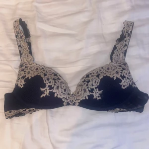 Mörblå Intimissimi bh - Mörkblå intimissmi bh med vita spetsdetaljer. Välanvänd men fortfarande i bra skick och har inga defekter.