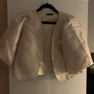 Beige blus från Stockh LM - Elegant beige blus från Stockh LM med korta ärmar och en stilren design. Använd få gånger men så fin verkligen. Nypris 800kr
