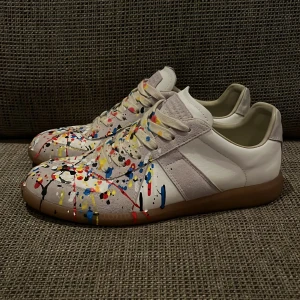 Färgstänkta sneakers från Maison Margiela - Säljer nu mina skor från maison margela för lägre pris än vanligt då jag ej har kvitto eller låda kvar pga flytt. Jag har kvar dust skydd till skorna men inte mer än det. Tvär feta till sommaren och priset går att disskyteras. Är även öppen för byten 👍