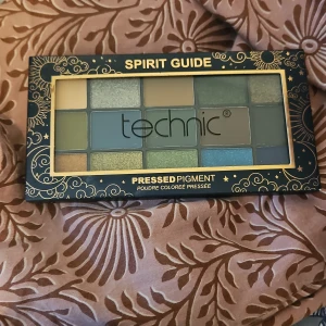 Ögonskuggspalett Spirit Guide från Technic - Färgglad ögonskuggspalett från Technic med namnet Spirit Guide. Innehåller 15 olika nyanser i gröna, blå och jordnära toner. Perfekt för att skapa både vardagliga och dramatiska looks. Paletten har en elegant förpackning med guldiga detaljer.