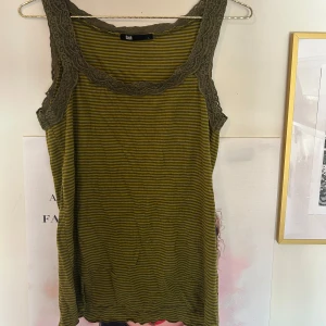 Grön randig linne med spets - Randigt linne med spets, jättegulligt till allt 😍 Strl L egentligen men passar typ alla! Ganska stretchig.