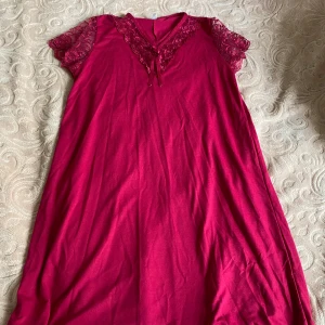 Rosa nattlinne - Säljer ett vackert nattlinne med spetsdetaljer och en liten rosett framtill. Nattlinnet har korta ärmar och en v-ringad design. Perfekt för en skön natt sömn. Den är väldigt använd och därför är materialet slitet som du ser i bilden men super skön att sova i😁