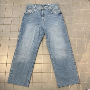 Blå jeans med rak passform - Säljer ett par klassiska blå jeans med rak passform. De har en hög midja och har avklippta ben från tidigare ägare. Säljer dem vidare då dem är stora på mig. Dem är stora i storleken och har avklippta ben så inte full längd men i väldigt gott skick.