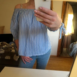 Blå- och vitrandig offshoulder topp från H&M - Säljer en sommrig och luftig topp från hm💕💕