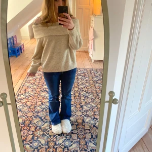 Beige offshoulder tröja - Säljer en snygg beige offshoulder tröja med ribbade detaljer. Perfekt för en stilren och avslappnad look. Passar bra till jeans eller kjol. Hör av dig vid intresse!