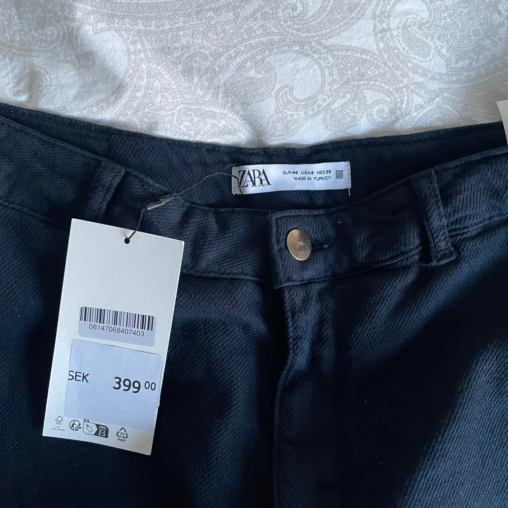 Snygga svarta byxor från Zara med en klassisk design. De har en rak passform och är tillverkade i ett bekvämt material. Perfekta för en stilren look.. Farkut & Housut.