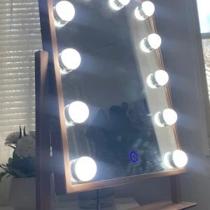 Sminkspegel med LED-lampor - Elegant sminkspegel med inbyggda LED-lampor runt ramen för optimal belysning. Spegeln har en stilren design med en ram i roséguld och en touch-kontroll för att justera ljusstyrkan. Perfekt för att få till den perfekta sminkningen hemma. Köptes för 700kr
