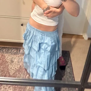 Ljusblå långkjol med volanger - Säljer en ljusblå långkjol med flera lager av volanger. Jättefin och skön i materialet💞står s/m i kjolen men skulle säga att det är en S