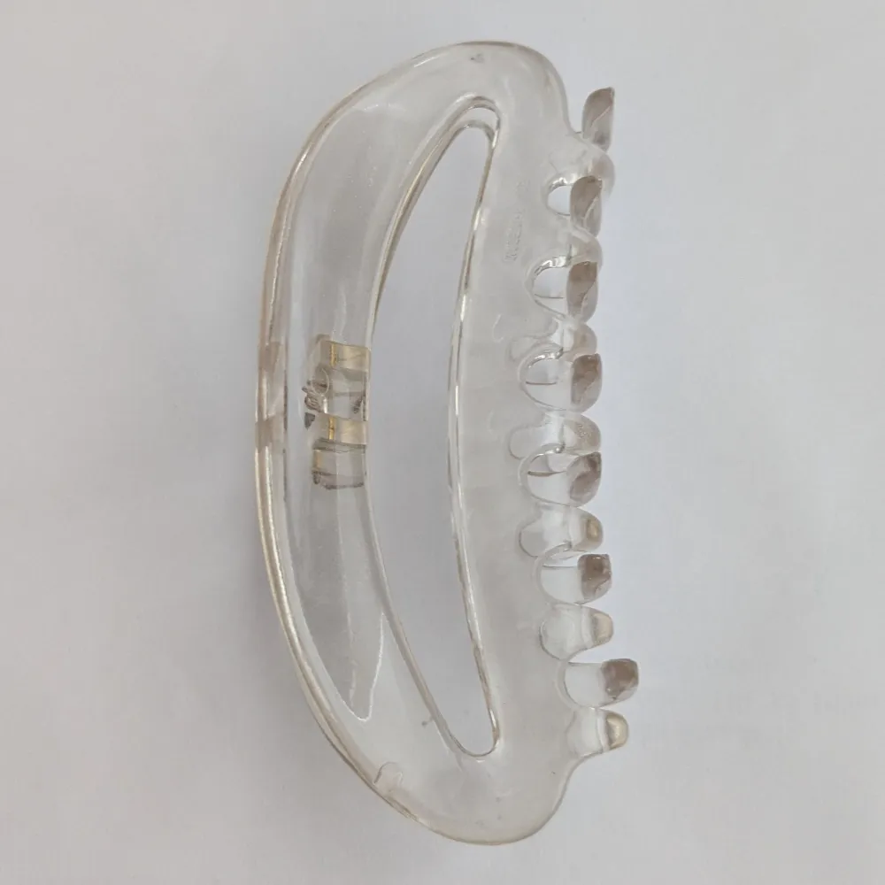 Säljer en stilren och transparent hårklämma i plast. Perfekt för att enkelt sätta upp håret med stil. Klämman har en klassisk design med en stark fjäder för bra grepp.. Asusteet.