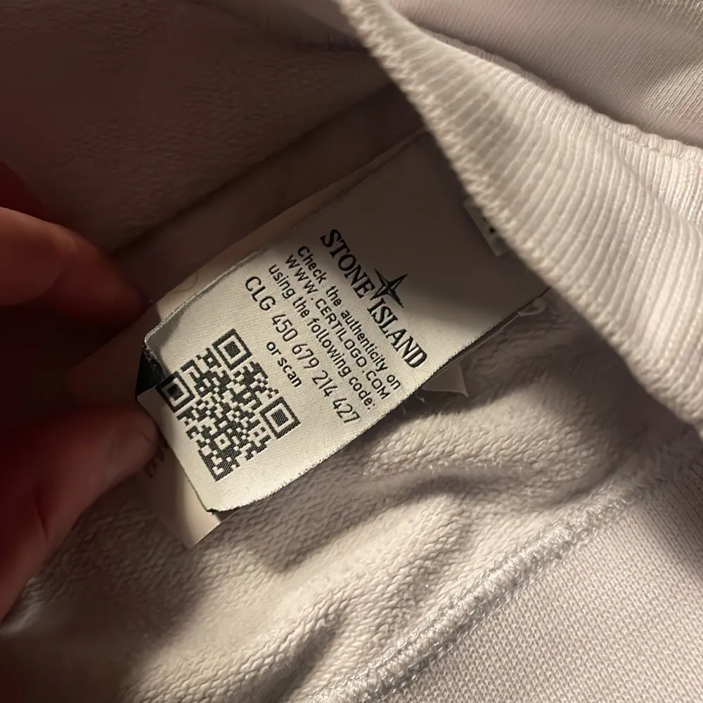 Säljer en stilren vit sweatshirt från Stone Island med deras ikoniska märke på ärmen. Tröjan har långa ärmar och ribbade muddar vid ärmslut och nederkant. Perfekt för en casual look. Nackdelar är att den har lite fläckar på armen som tyvär går inte bort.. Neuletakit & Villapaidat.