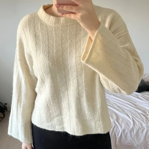 Gina Tricot - Säljer en vit stickad tröja från Gina Tricot. Tröjan har ett diskret randigt mönster och långa ärmar. Perfekt för en avslappnad och trendig look. Passar bra till både jeans och kjol. Bra kvalitet, endast lite nopprig under armarna